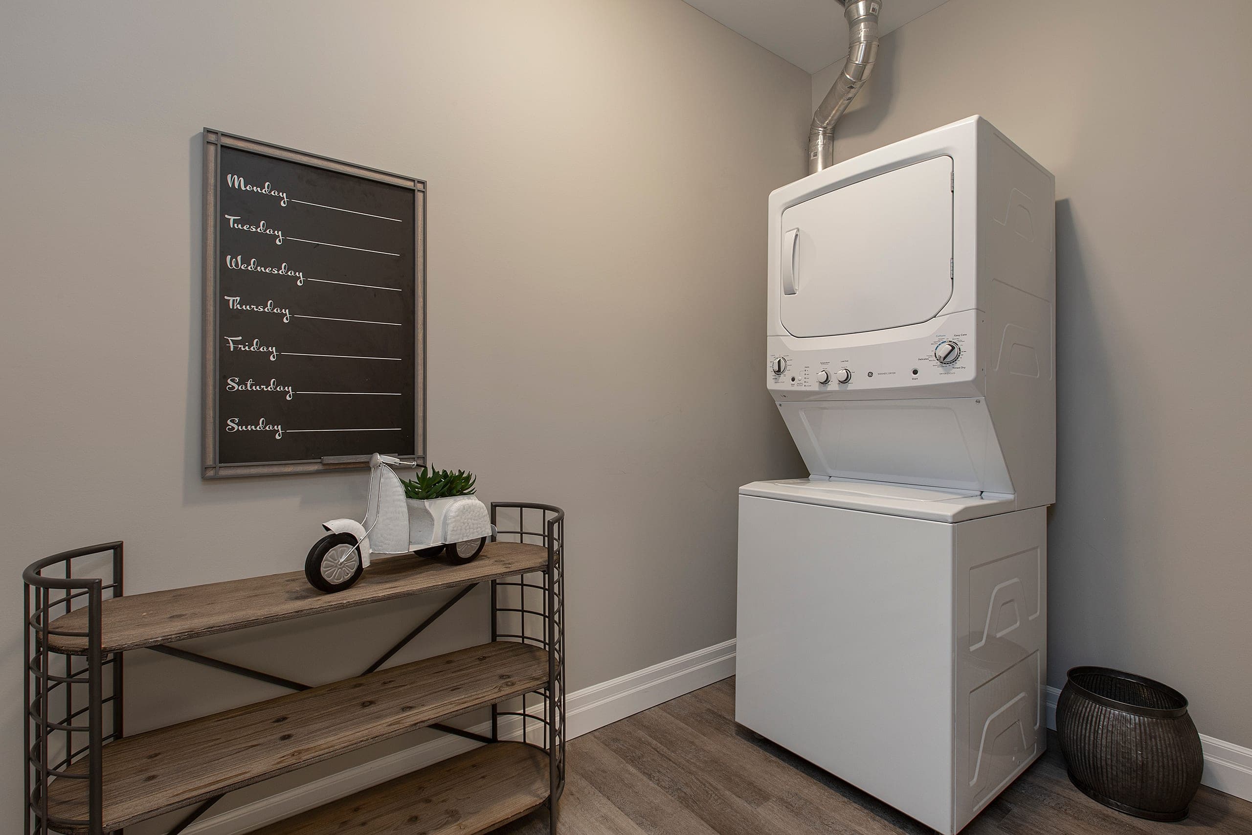 Stacked washer and dryer beside a console table in a suite at The Frontenac